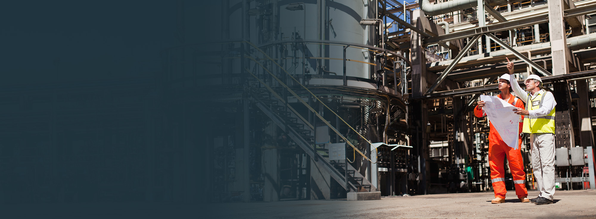 site-engineer-pointing-at-refinery-asset-with-gradient-overlay